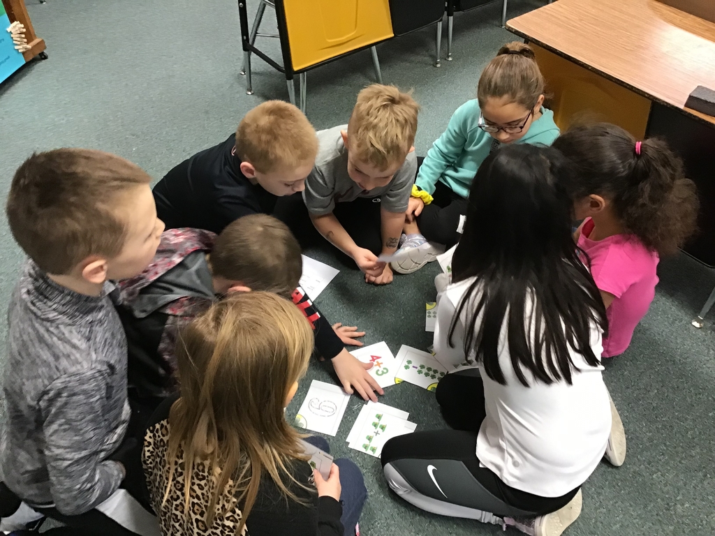 Eight students in a circle looking at the clues.